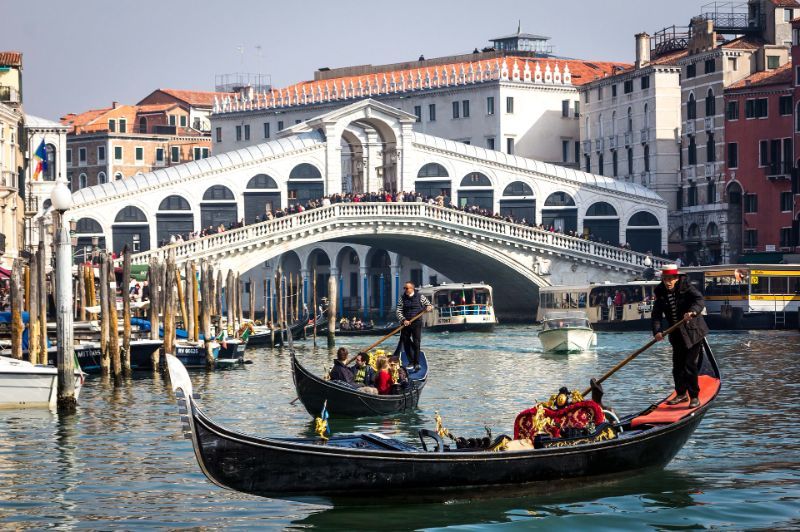 A family enjoying a gondola ride in venice.