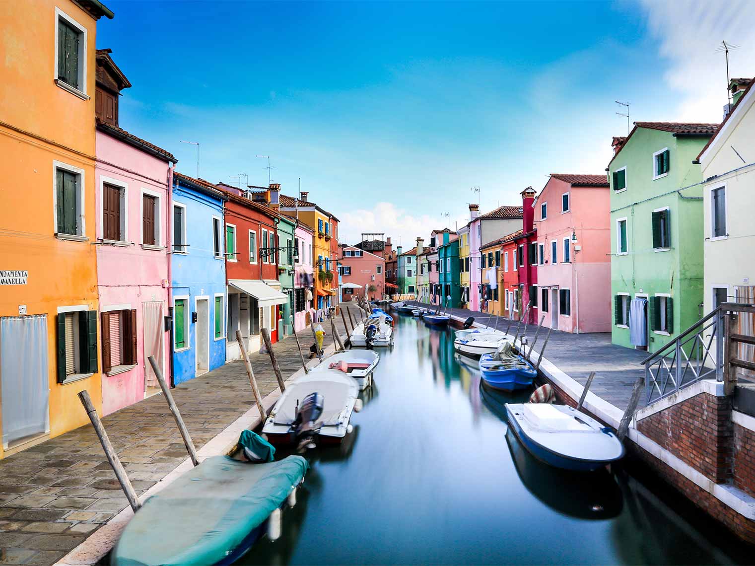 boats lined along the canal on tour of Murano.