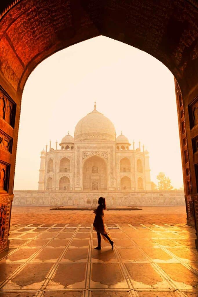 Silhouette unidentified woman tourist walking near Taj Mahal in Agra India_