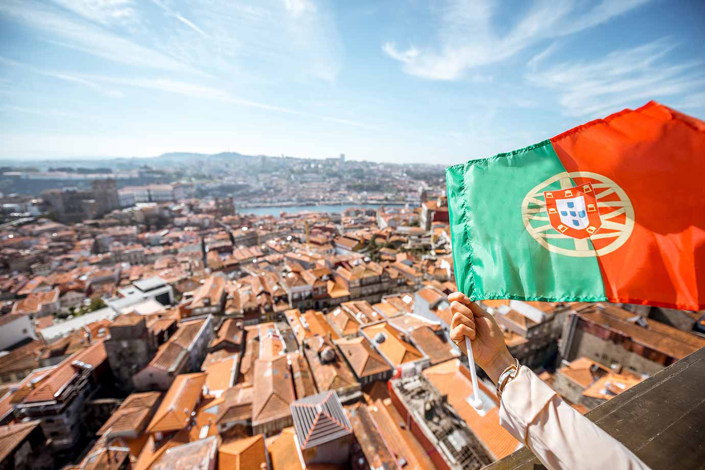 Aerial cityscape view on the old town with Portuguese flag in Porto, Portugal, Clerigos Tower