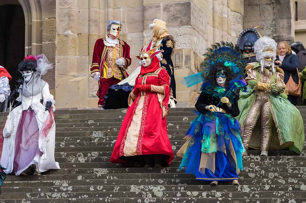 people in costumes and venetian masks at venice carnival