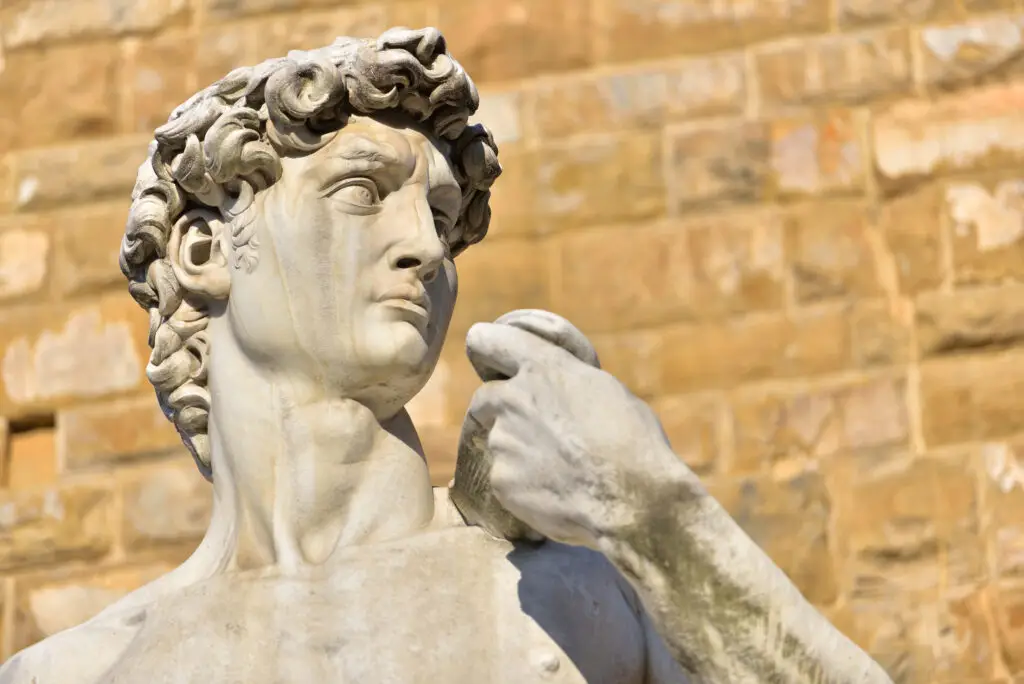 Close-up of Michelangelo's David statue at Piazza della Signoria in Florence, showing detailed marble sculpting and expressive features.