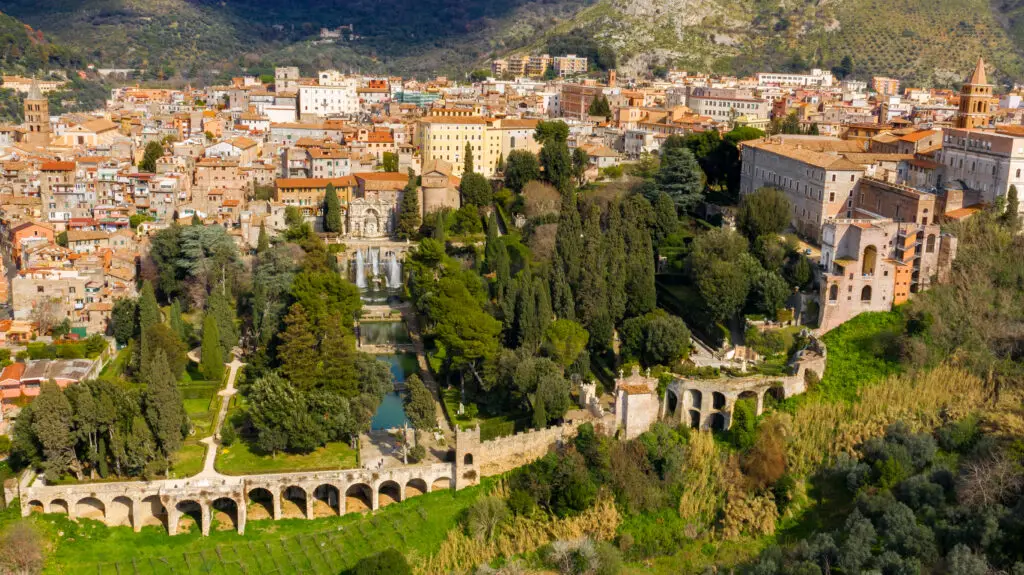 Aerial view of Villa d'Este in Tivoli, showcasing the intricate Renaissance architecture, expansive gardens with lush greenery, and the iconic fountains and waterfalls, near Rome, Italy, a UNESCO World Heritage Site.