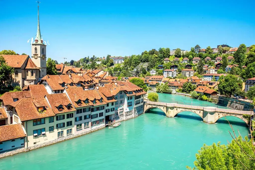Scenic view of Bern, Switzerland showing the historic architecture along the Aare River with a clear blue sky.