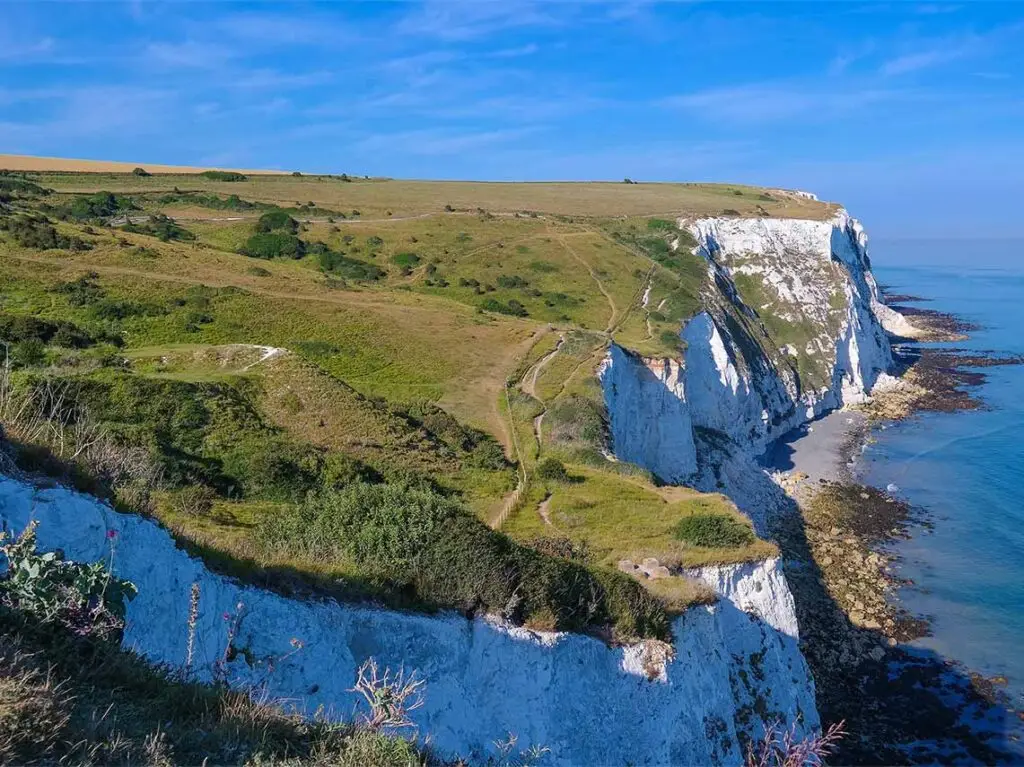 Panoramic view of the iconic white Cliffs of Dover on the English coastline, a popular destination for scenic tours in England.