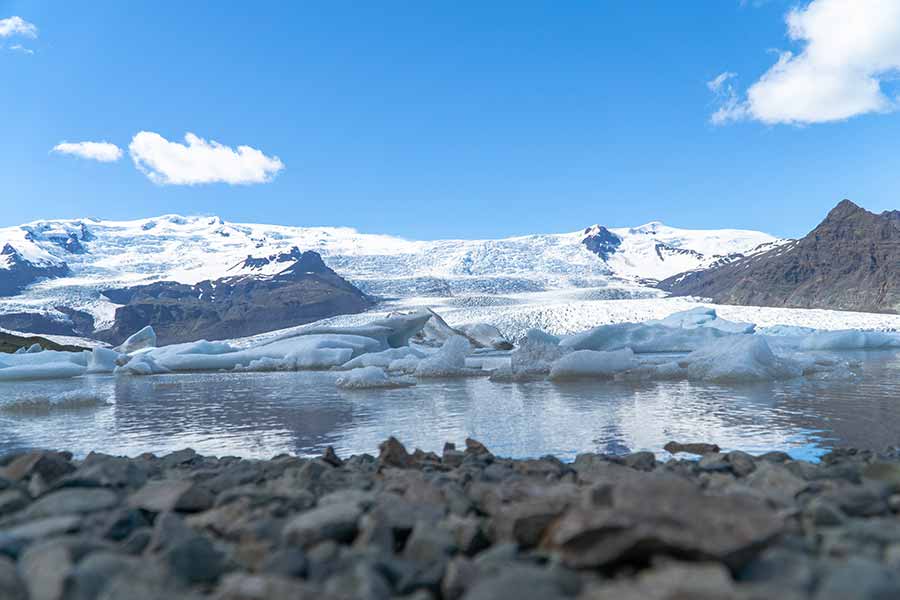 Scenic view of Fjallsárlón Glacier Lagoon with floating icebergs and towering glacier in the background, Iceland