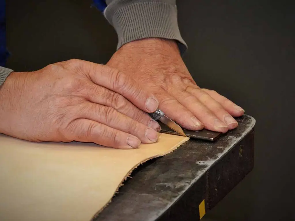 Artisan crafting leather by hand in a Florence workshop during a cultural tour