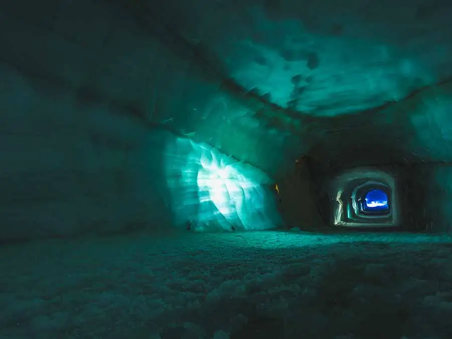 Ethereal view inside the icy corridors of Langjokull Glacier, a popular ice cave in Iceland, illuminated by a natural blue glow.