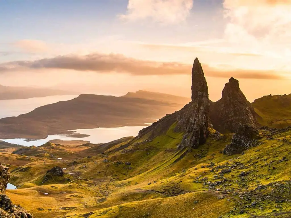 Breathtaking sunrise view over the Old Man of Storr on the Isle of Skye, Scotland, showcasing dramatic peaks and serene lake in the distance