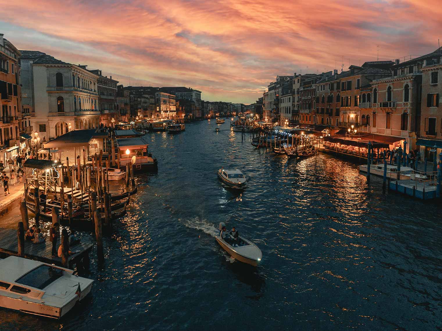 Luxurious private boat ride during sunset on the Grand Canal in Venice, showcasing scenic waterways and historic Venetian architecture.