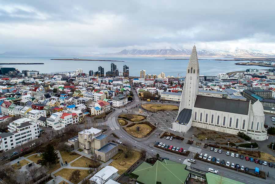 Aerial view of Reykjavik cityscape with Hallgrimskirkja Church, showcasing the vibrant architecture and scenic coastline of Iceland.