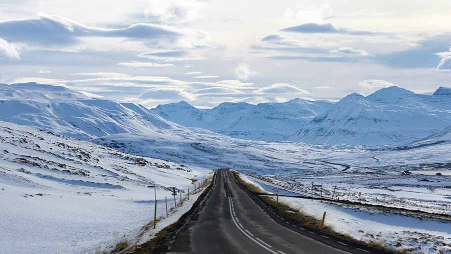 Scenic view of Skagafjordur Valley Road in Iceland during winter with snow-covered mountains and clear roads.
