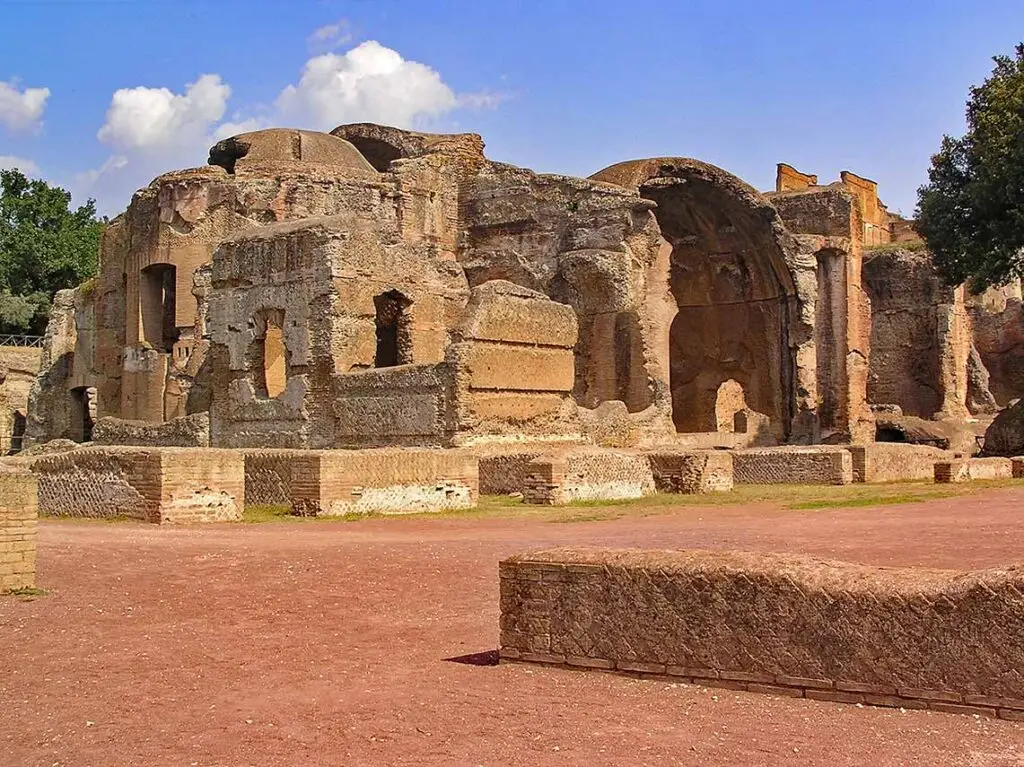 Ancient ruins of Villa Adriana in Tivoli, Italy, showcasing extensive brickwork and historical architecture under clear blue sky.