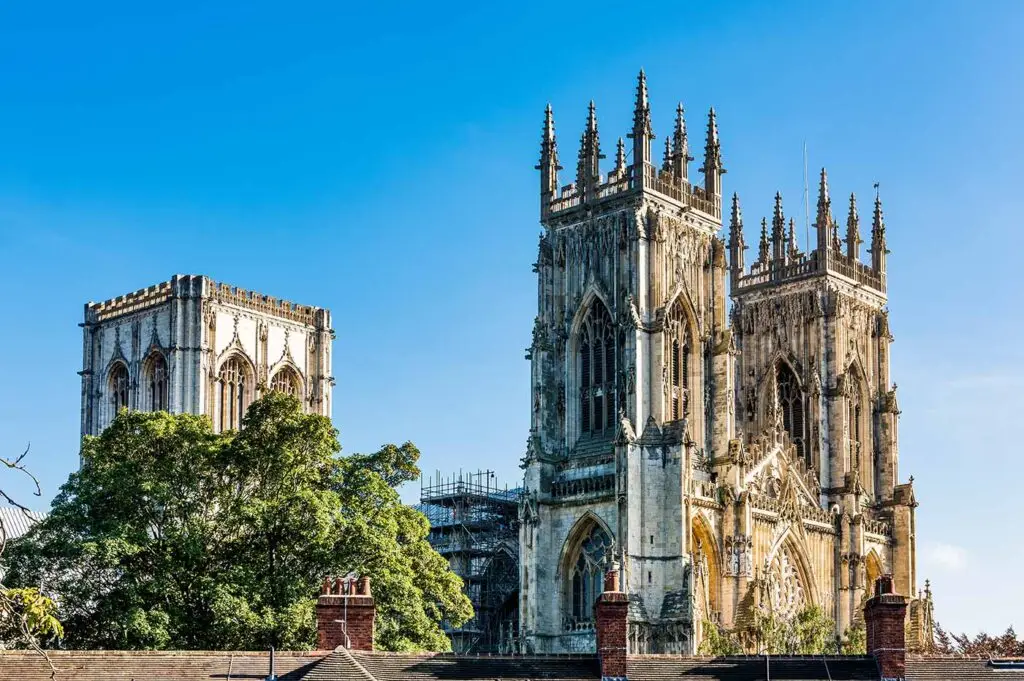 Breathtaking view of York Minster Cathedral under clear blue skies in North England, showcasing intricate Gothic architecture and historical significance.