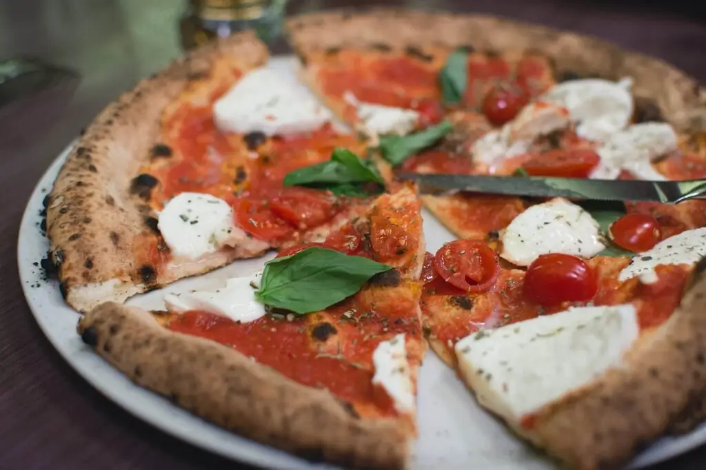 Authentic Margherita pizza with fresh basil, mozzarella cheese, and cherry tomatoes, a classic Italian dish.