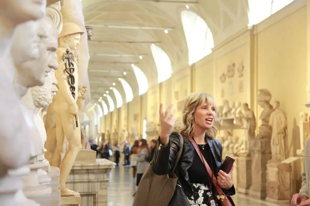Excited female tourist exploring historical statues in the Vatican Museums, Italy